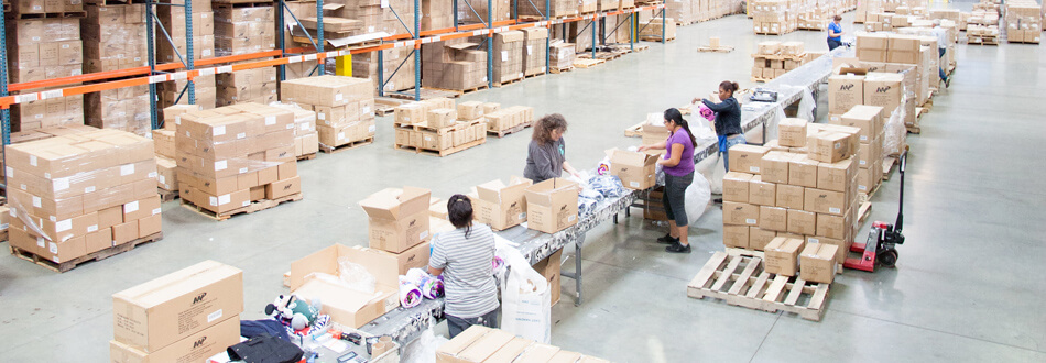 Workers gathered in the center of the warehouse for kitting and assembly.